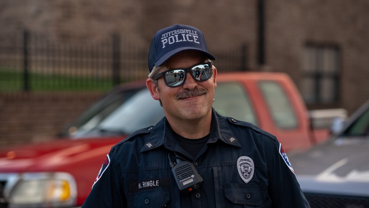 A smiling Jeffersonville officer in a JPD cap