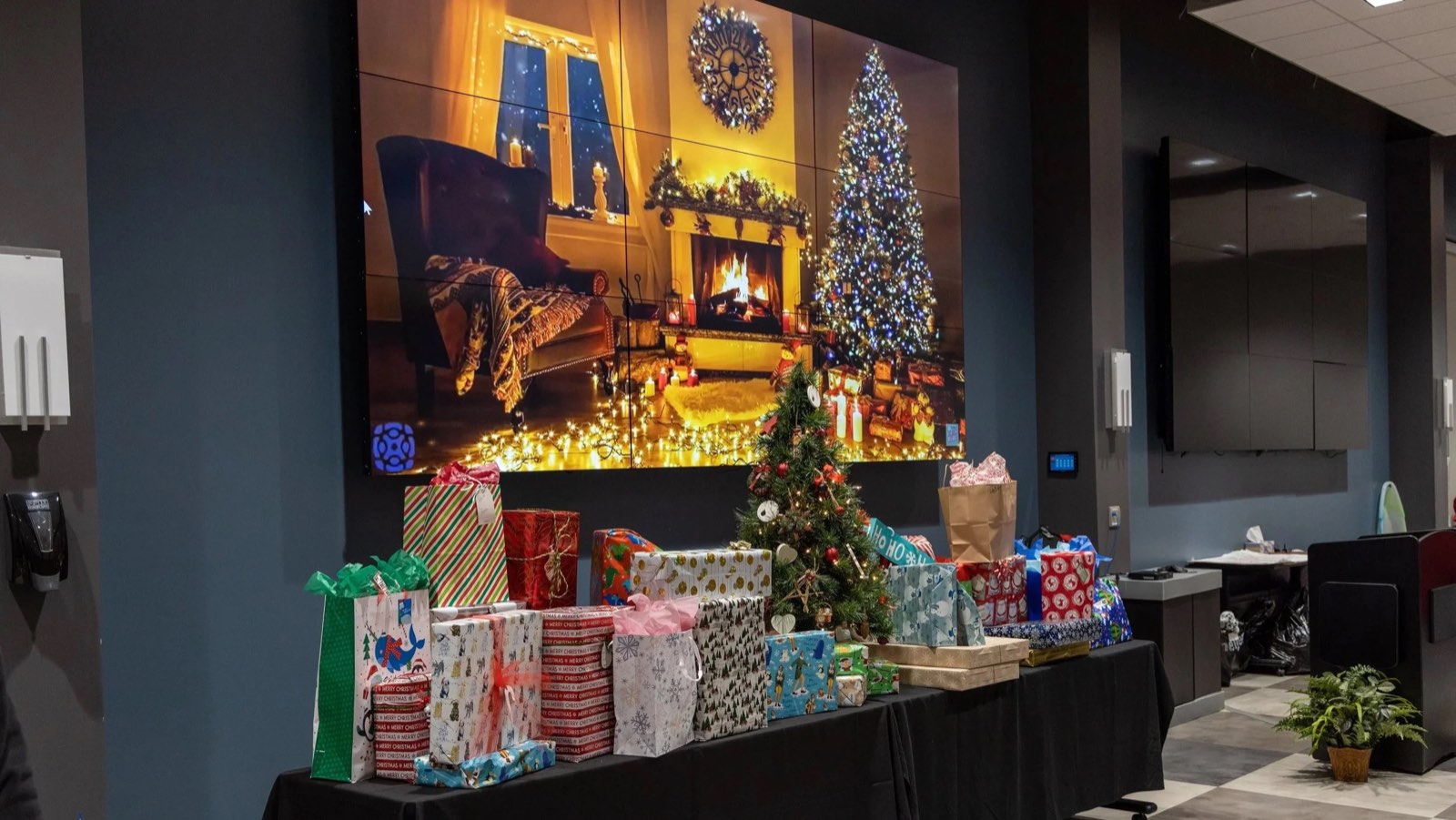 A table stacked with wrapped gifts ready for Shop With A Cop families at the police station