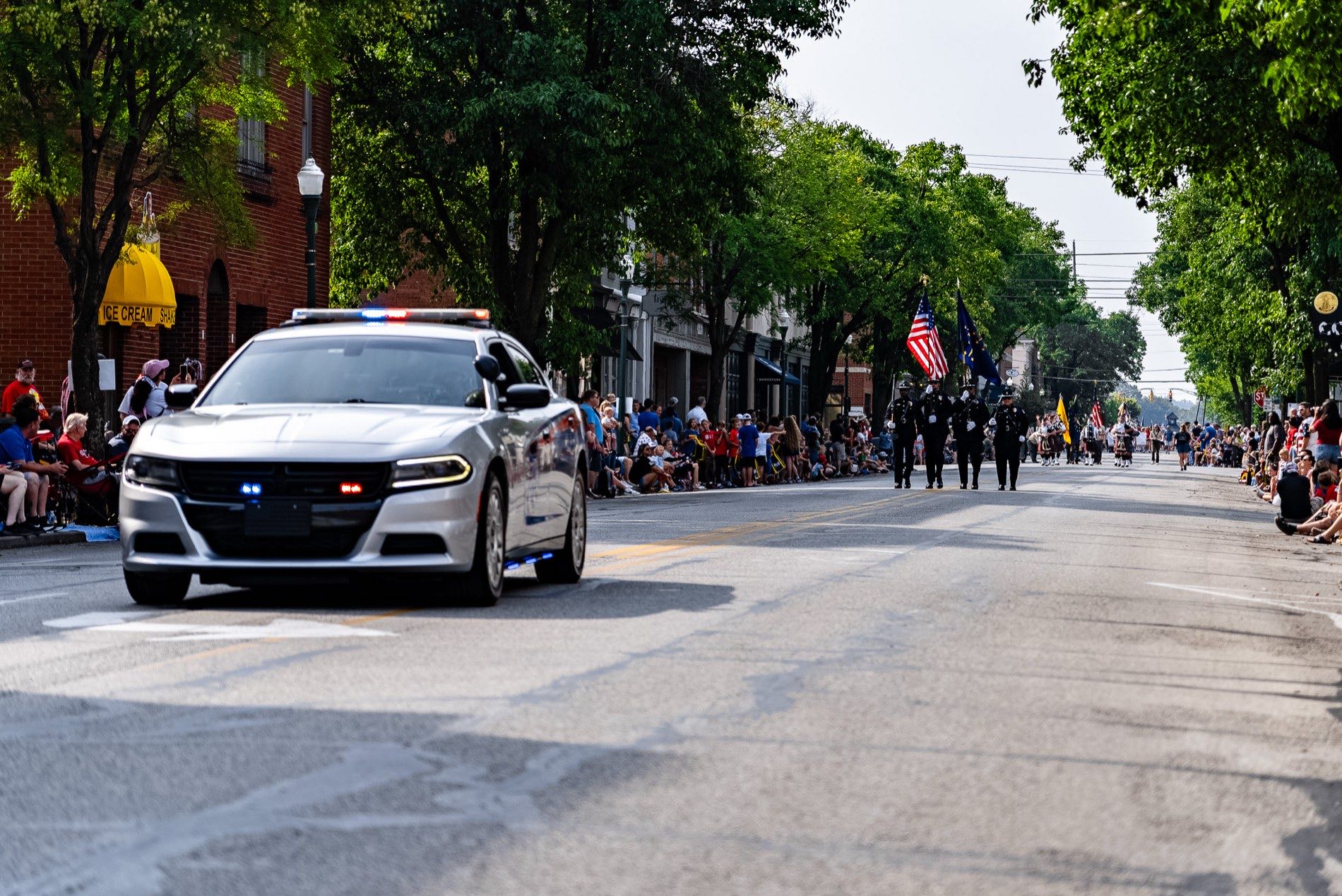 A Jeffersonville Police cruiser leading the honor guard down Spring Street during a parade